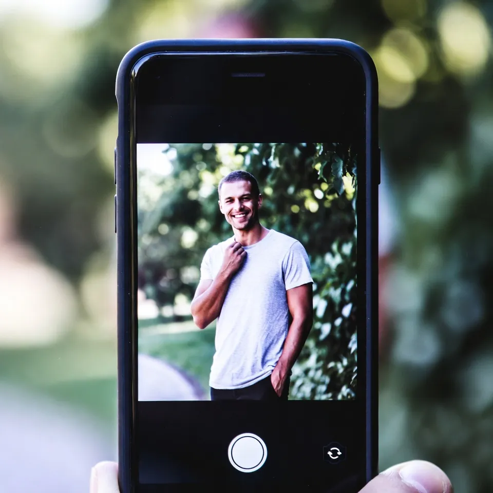 A person smiling thoughtfully while enjoying a peaceful outdoor walk in natural daylight