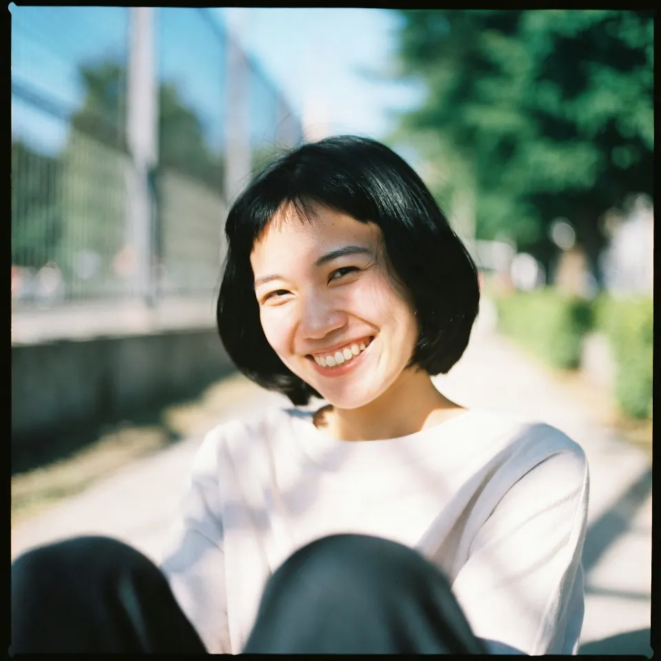 A person smiling warmly while relaxing in a green park during daytime